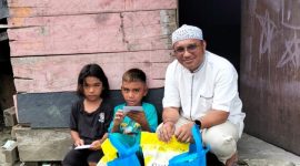 Kepala Dinas PMD Halsel, M Zaki Abd Wahab saat menyapa Dua anak Yatim di Desa Wayamiga Kecamatan Bacan Timur. (Foto: Shain MalutInsight.net)
